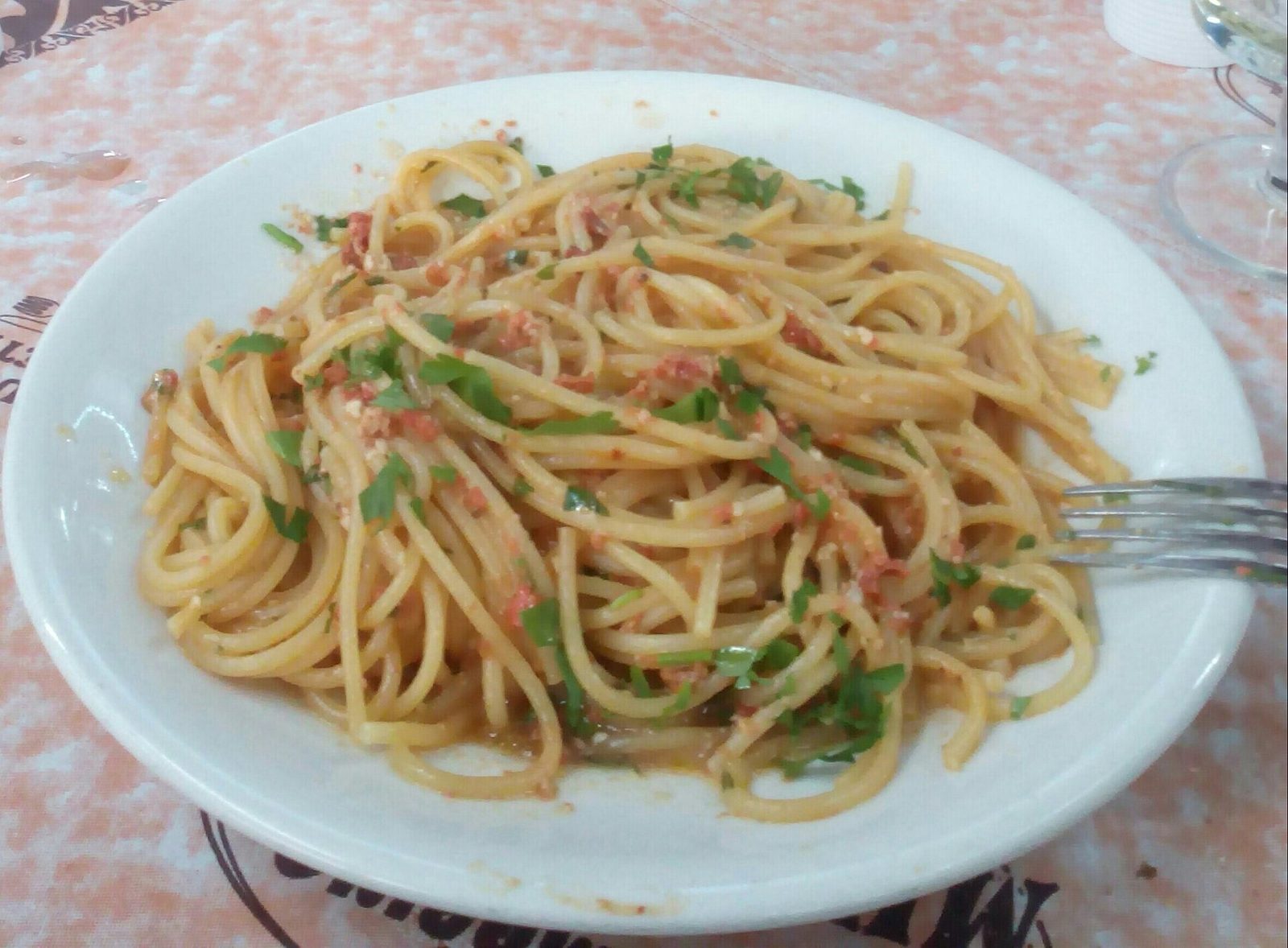 Piatto di spaghetti ai ricci di mare con prezzemolo, specialità di mare della cucina sarda